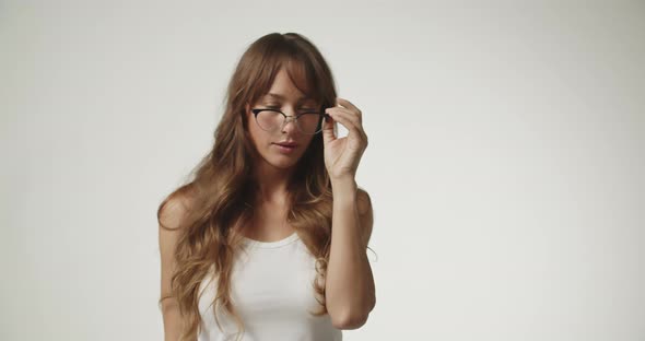 Woman With Long Hair Wearing White And Removing Glasses