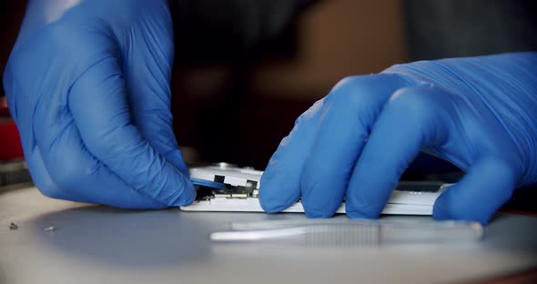Repairman in Electronics Repair Service Using Special Tools Opens the Phone for Repair Close Up View alt
