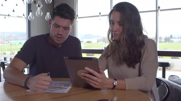 Two young people working together with digital tablet