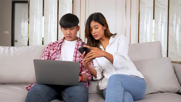 Young man working on laptop and disinterested girlfriend alt
