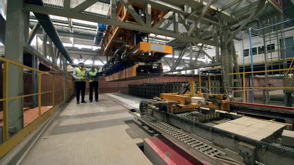 Male Technicians Are Observing Production Process on a Modern Industrial Equipment alt