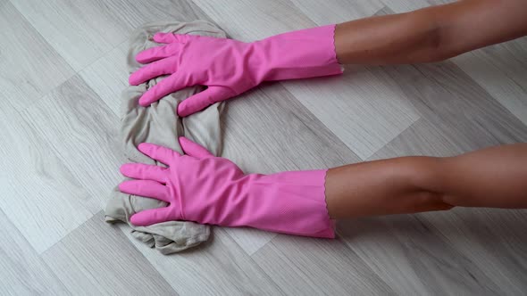 Women's Gloved Hands with a Rag Wash the Floor Laminate