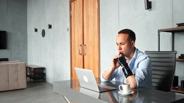 Thoughtful cyborg programmer with black bio hand prothesis looks at laptop screen alt