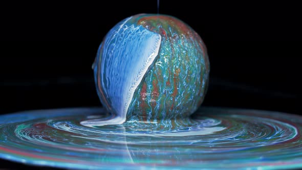 Paint Flows Down the Surface of the Texture Ball and Spreads Over the Table alt