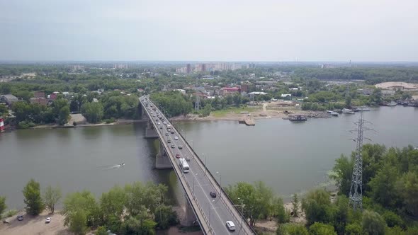 Cars Are Moving Over Modern Bridge Through River in Summer Day, Aerial View