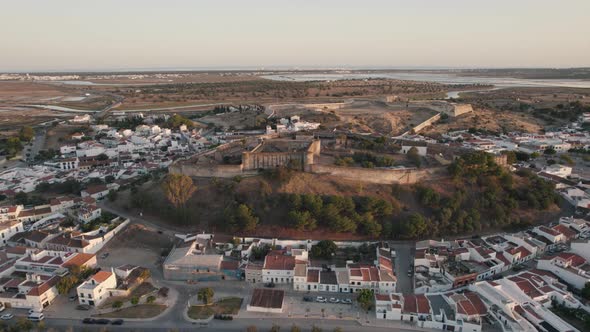Pan left shot of hilltop fortification Castelo de Castro Marim Castle and fort São Sebastião. alt