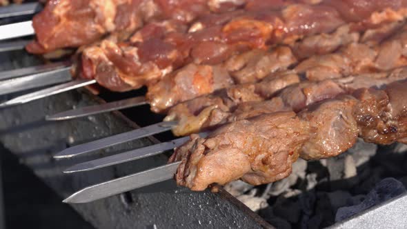 Pork Barbecue Cooking on Metal Skewers on Charcoal Grill with Fire Smoke