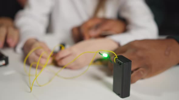 Girl Takes Probes From Chip to Turn Off Lamp with Teacher alt