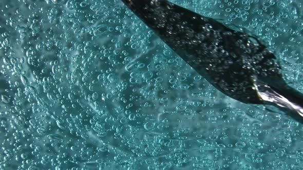 Motion Rotation of the Liquid Gel Fluid Blue Cosmetic Cream Texture with Bubbles alt