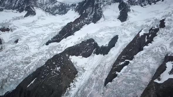 Aerial approach in the swiss alps to a mountain cliff with big glacier in the Grindelwald region alt