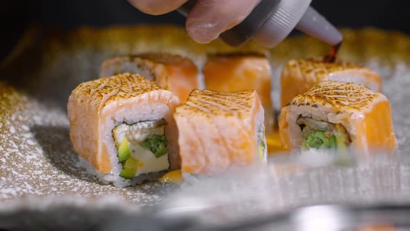 Cook Pouring Sauce of Sushi Rolls alt