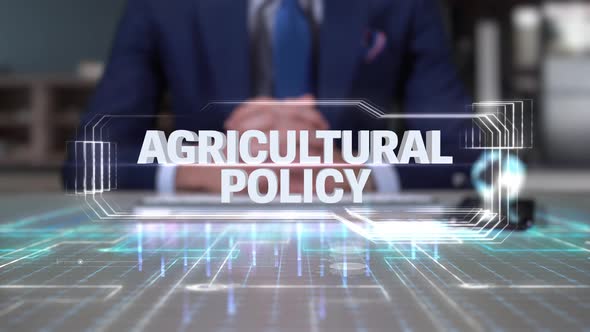 Businessman Writing On Hologram Table Economics Word  Agricultural Policy