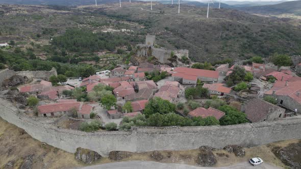 Ancient medieval walls of Sortelha village with granite rural houses, Portugal. Aerial circling