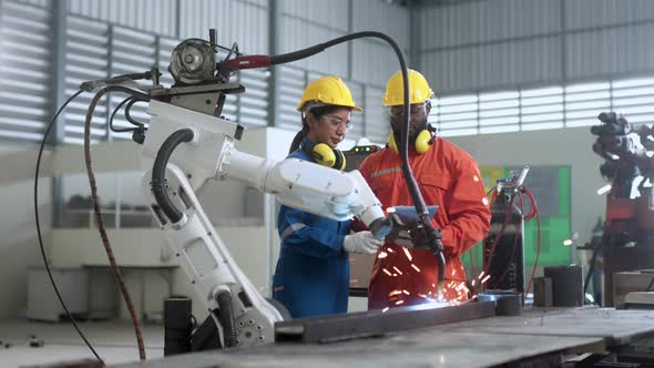engineer cooperation male and female technician maintenance control relay robot arm system welding