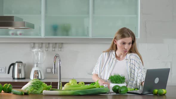 Vegetarianism Young Female Prepares a Salad in the Kitchen Cuts Herbs and Green Vegetables to Make a alt