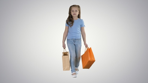 Little Girl with Shopping Bags Walking on Gradient Background alt