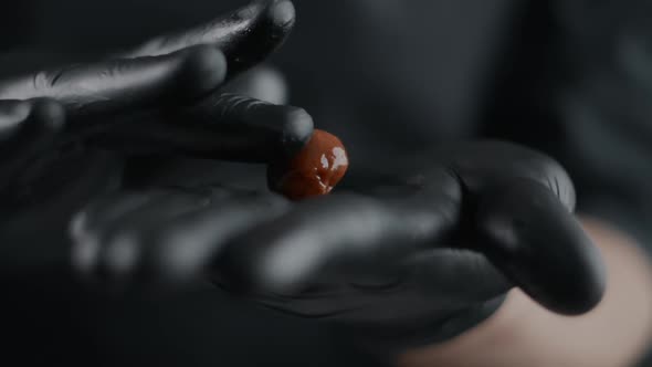 Chef Chocolatier in Black Gloves Rolls Up Small Candies From Self Cooked Chocolate in Slow Motion