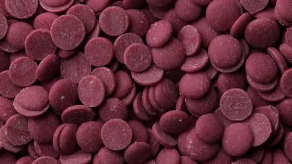 Ruby chocolate chips top view rotation. Camera moves away from the object alt