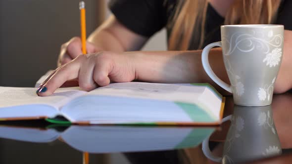 Girl Student Writes in Notebook at Home Closeup alt