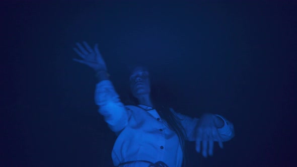Slow ecstatic dance of young woman in white dress in darkness night blue light Freedom mood relax alt