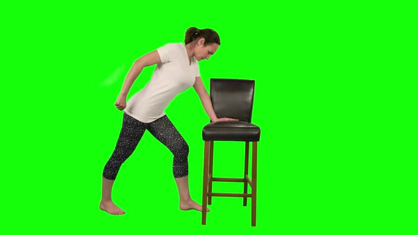 Fitness Woman Standing in Pose Leaning on Black Chair and Doing Exercises for Rehabilitation alt