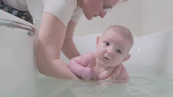 Mom and son are engaged in infant swimming 