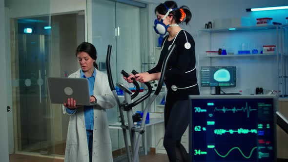 Doctor Scientist Holding Laptop Computer and Controling EKG Data alt