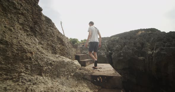 Following a Man Walking Up the Stone Stairs on the Rocky Cliff By the Ocean Male Tourist Ascending alt