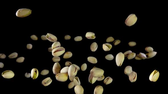 Green Pistachios Are Bounce on a Black Background alt