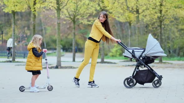 Woman with Two Children Walking in the Park alt