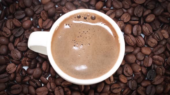 Pouring Coffee Into Mug On Coffee Beans