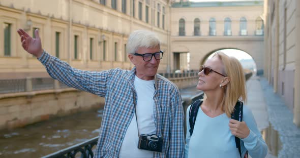 Mature Couple Walking on Street on Weekend Vacation Looking and Enjoying Architecture alt