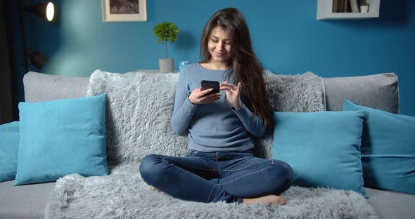 Brunette Lady Using Phone While Sitting on Sofa alt