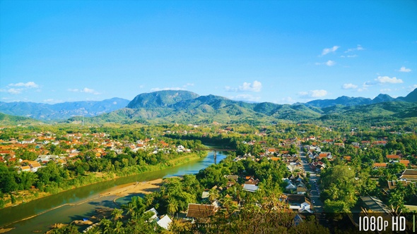 Overhead View of a Small City or Town Near a River with Views of Mountainous Landscape alt