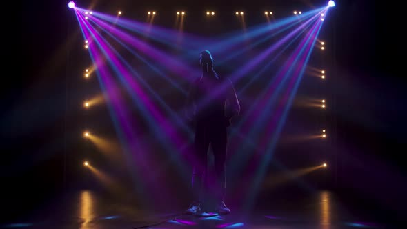 Silhouette a Young Stylish Guy Vocalist Singing and Gestures with His Hands on Stage in a Vintage alt