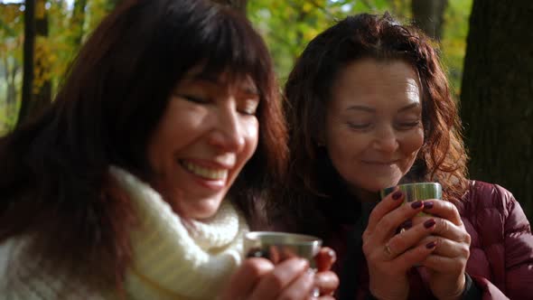Closeup of Happy Smiling Mature Women Drinking Tea Standing in Sunny Autumn Forest alt