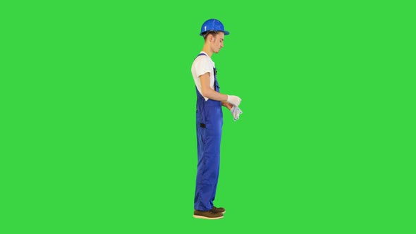 Construction Worker Wearing Protective Gloves on a Green Screen Chroma Key alt