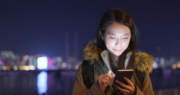 Asian woman use of smart phone in city at night alt