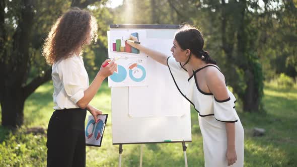 Side View Two Young Women Discussing Business Idea Outdoors Arguing in Slow Motion alt