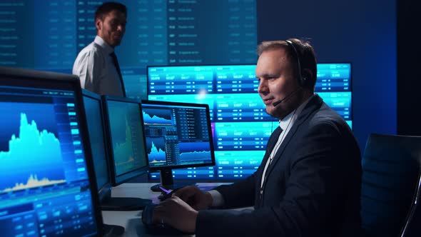 Team of brokers is working in office using workstation and analysis technology. alt