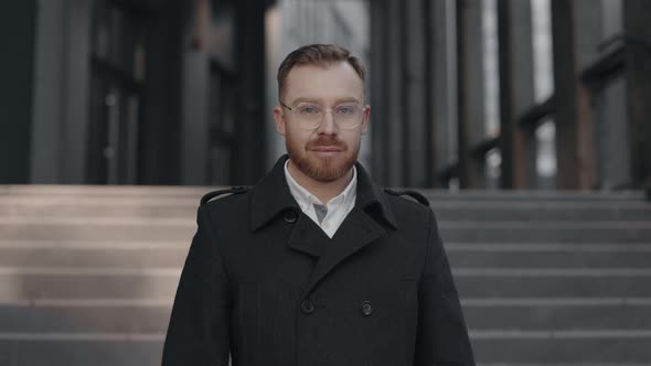 Businessman Smiling Cheerfully to Camera at Street Near Business Center alt