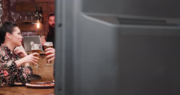 Drinking Beer, Eating Peanuts and Watching a Game on TV in a Vintage Pub alt