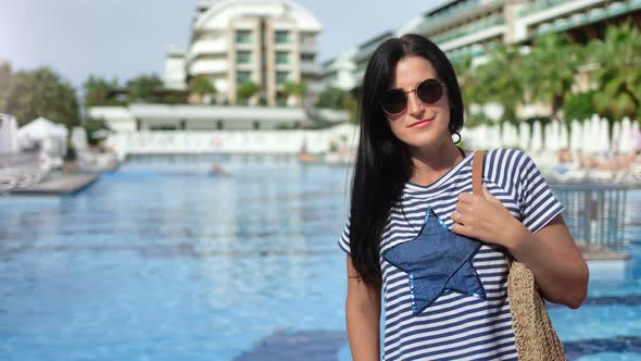 Travel Brunette Woman in Sunglasses Smiling Posing at Swimming Pool Hotel Background alt