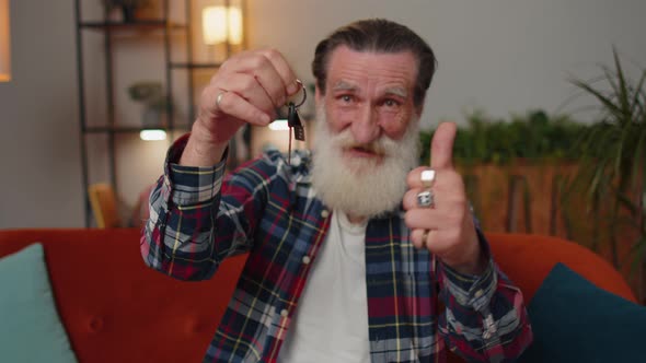 Senior Man Real Estate Agent Showing the Keys of New Home House Apartment Buying or Renting Property alt