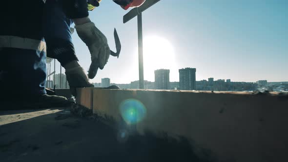 Workman Uses Trowel While Laying Bricks alt