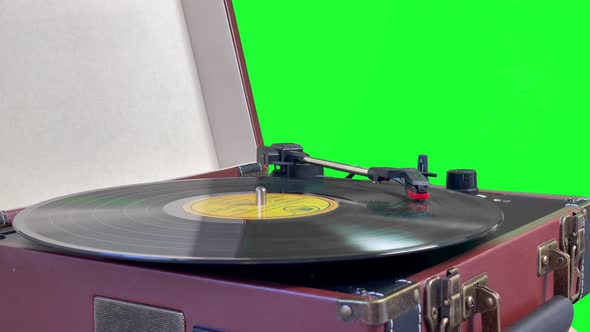 A Retro Portable Turntable Isolated on Green Background. 4K.