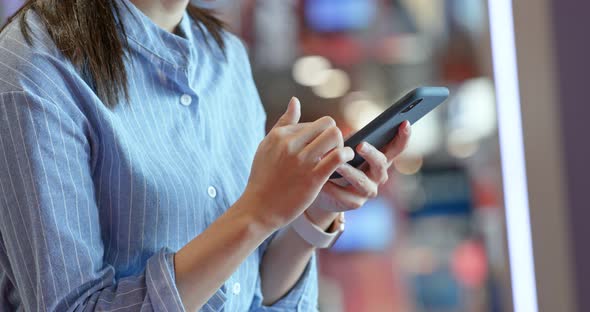 Woman use of cellphone inside shopping center alt