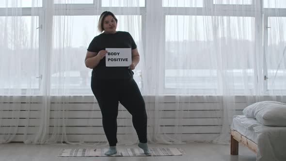 Concept Body Positivity  a Chubby Smiling Woman Holds a Sign with the Inscription BODY POSITIVE alt