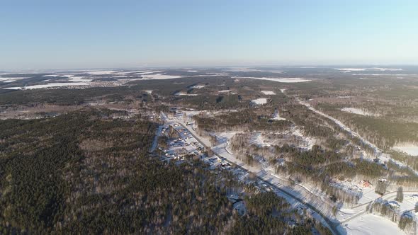 Aerial drone view of Winter cottage village located among endless forests 01 alt