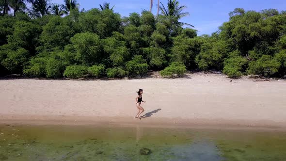 Pretty Woman in Black Swimsuit Running Alone on the Beach Thailand